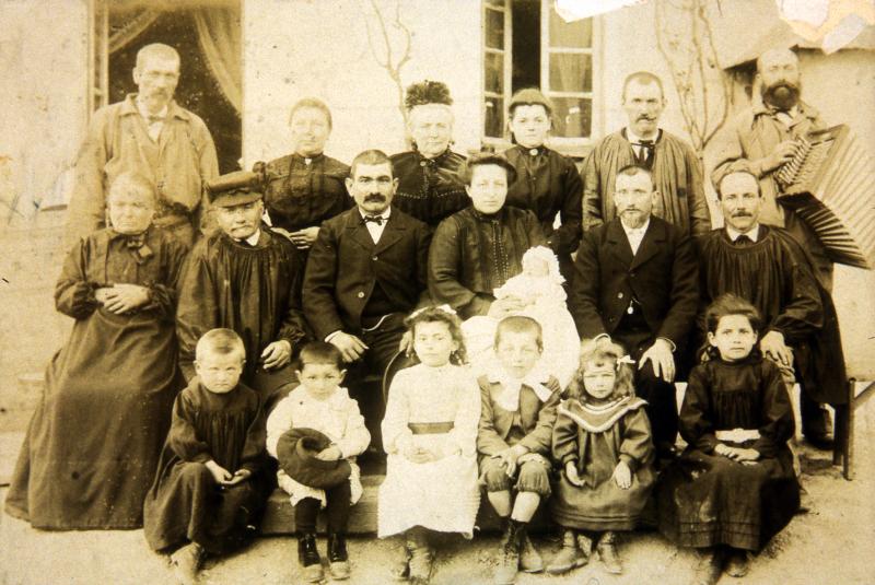 Famille en habits (vestit) traditionnels et accordéoniste (acordéonista) le jour d'un baptême (batejalhas) [?], dans le Naucellois (secteur de Naucelle), 1904